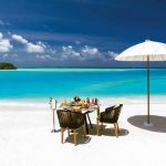 mesa con sombrila en la playa de Ozen by Atmosphere at Maadhoo