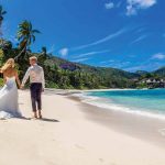 pareja en la playa de Kempinski Seychelles