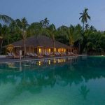 la piscina de The Residence Maldives at Dhigurah al atardecer