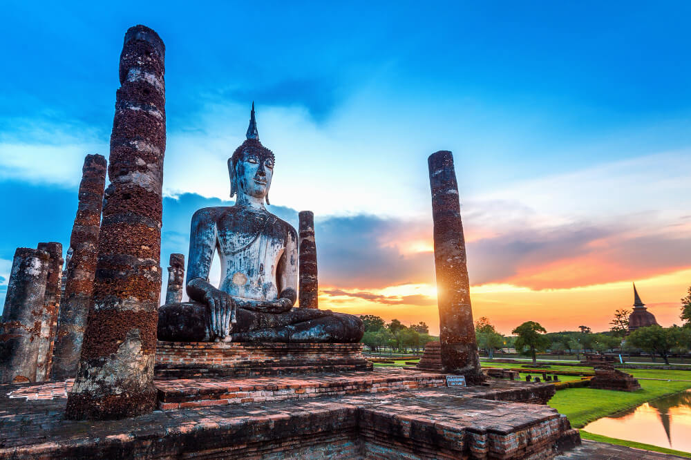 Estatua de Buda y templo wat mahathat en el recinto del parque histórico de sukhothai